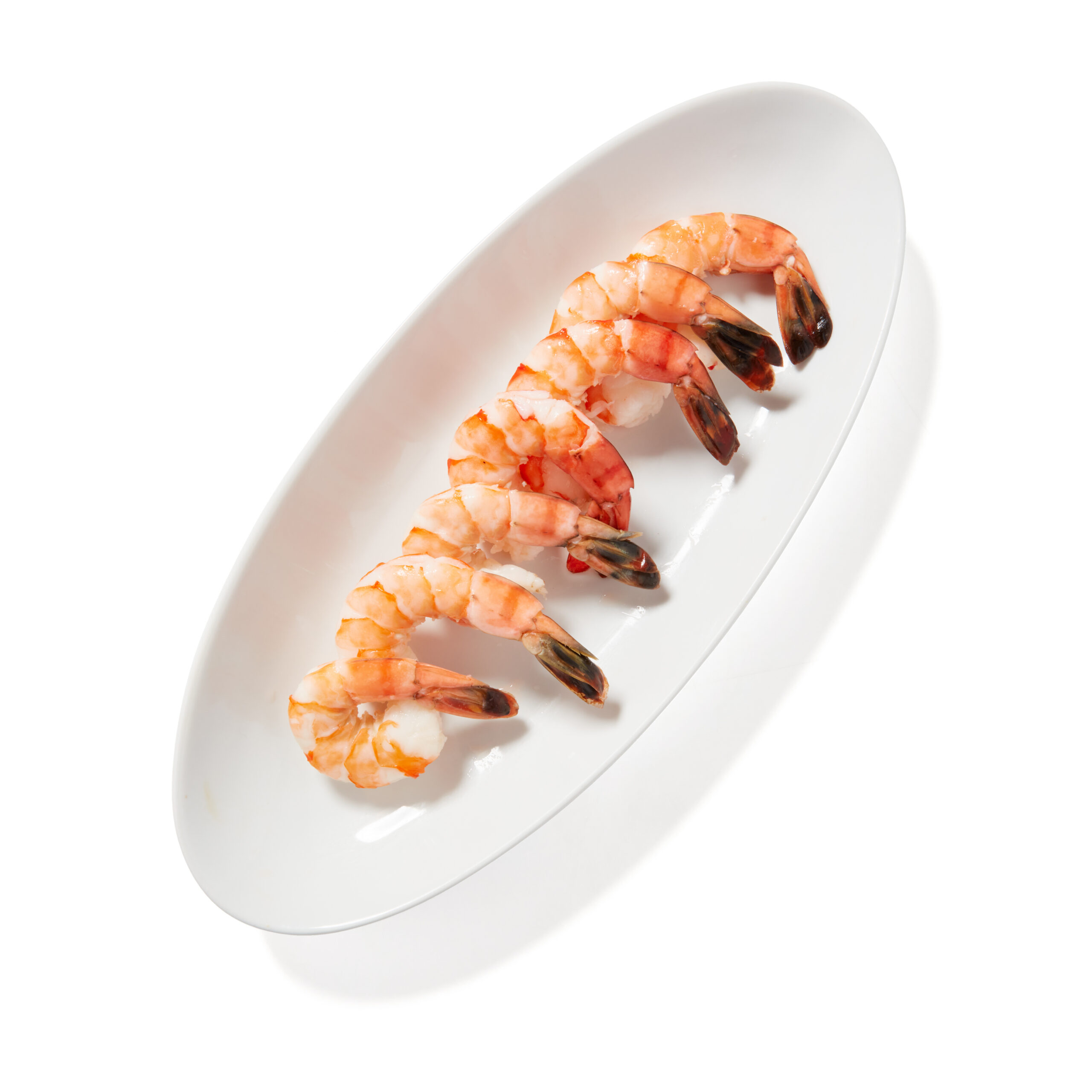 freshly cooked shrimp lined up on a plate